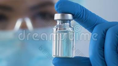 女科学家仔细检查了一小瓶解毒剂，以抵御危险毒物